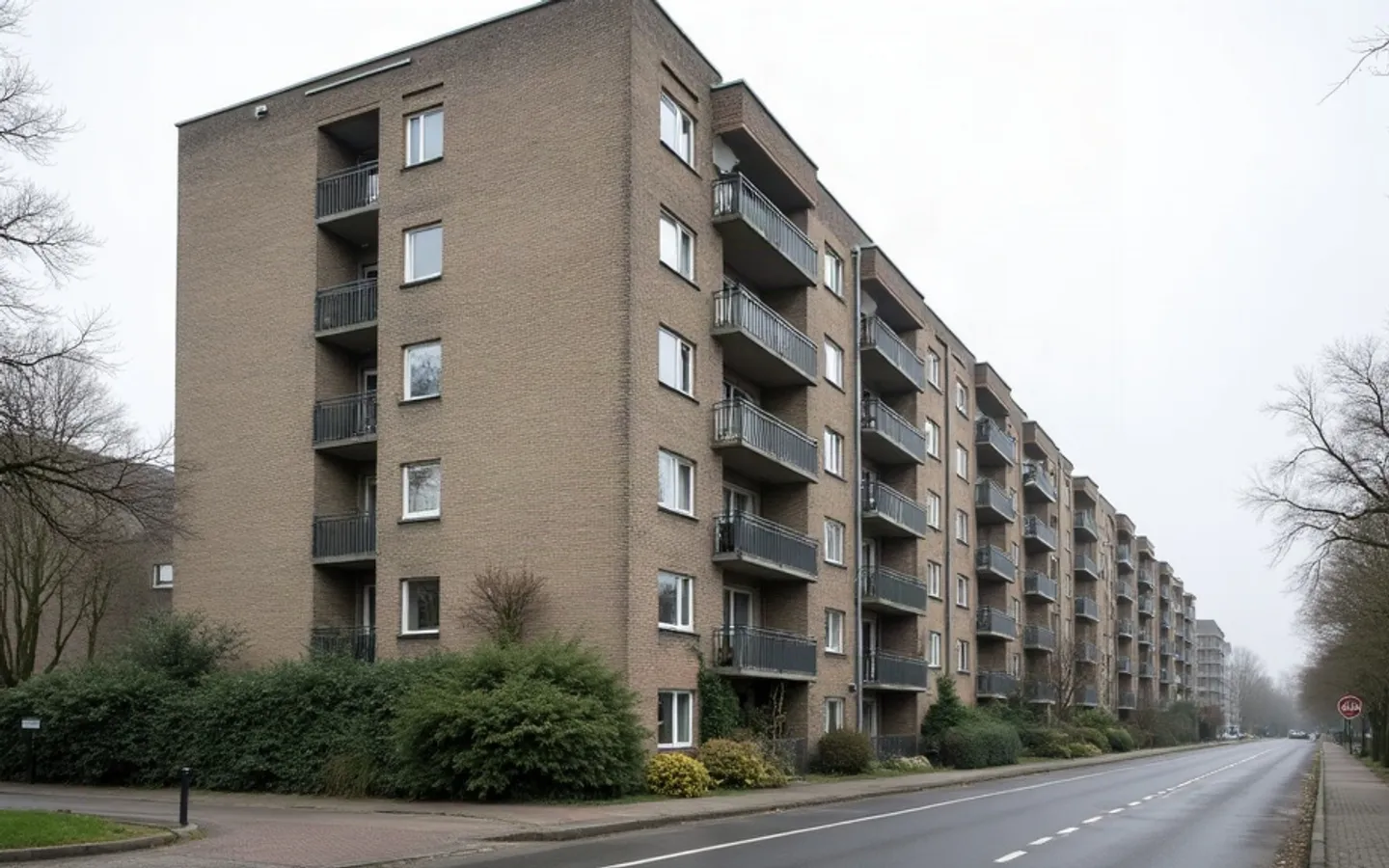 Wooncomplex van vijf lagen met balkons, langs een doorgaande weg